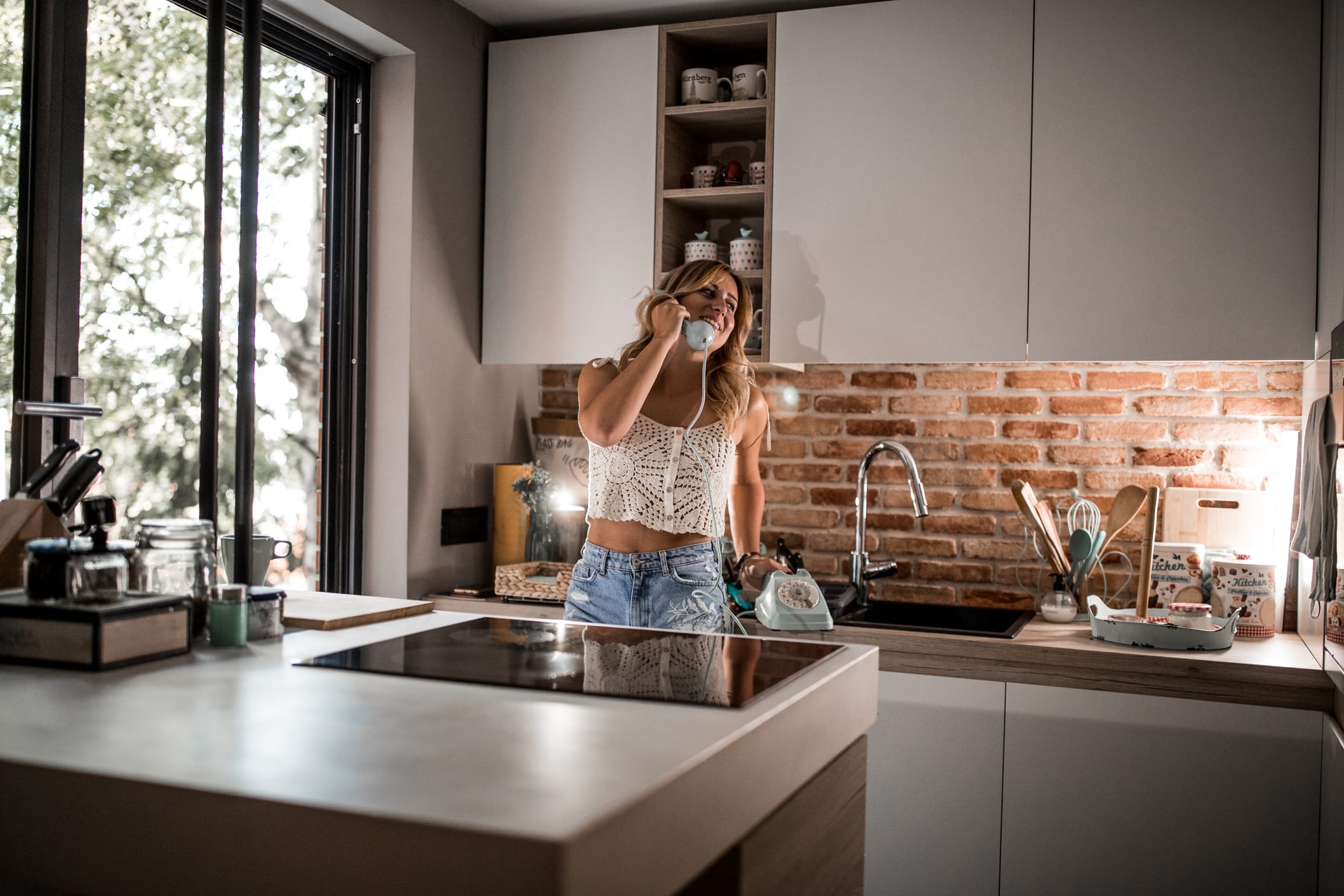 woman laughing will talking on the phone in the kitchen